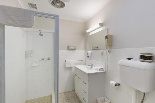 een badkamer met een douche, een toilet en een wastafel bij Alexander Motor Inn in Melbourne