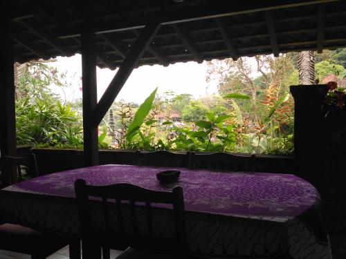 una mesa púrpura en una habitación con ventana en Dhangin Taman, en Tirtagangga