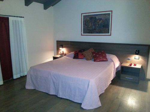 sypialnia z dużym białym łóżkiem i dwoma stolikami w obiekcie Hotel La Vecchia Reggio w mieście Reggio nell'Emilia