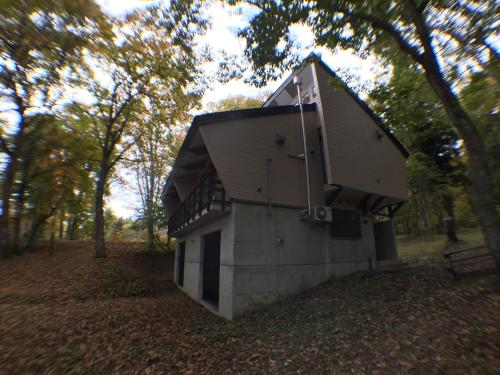 a small building in the middle of a forest at Labo Land Kurohime in Shinano