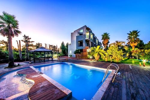 a swimming pool in front of a building at Mirvill Pension & Resort in Seogwipo