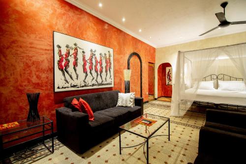 a living room with a couch and a bed at Mediterraneo Boutique Hotel in Dar es Salaam