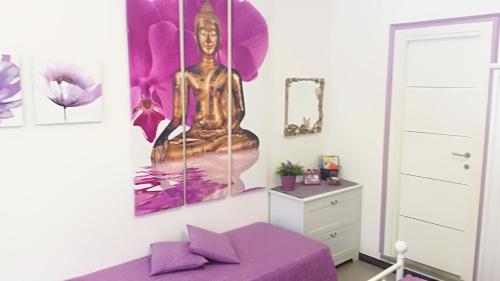 レーリチにあるCasetta Romantica Viola Lericiのベッドルーム1室(紫色のベッド1台付)が備わります。壁に絵画が飾られています。