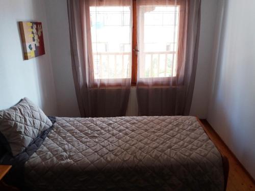 a bedroom with a bed and two windows at Traditional House Paschalis in Kavala