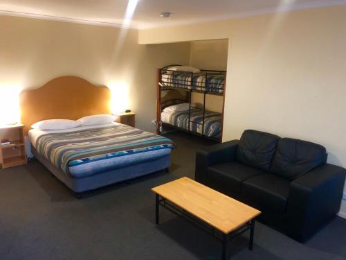 シェフィールドにあるSheffield Motor Innのベッドルーム1室(ベッド1台、ソファ、椅子付)