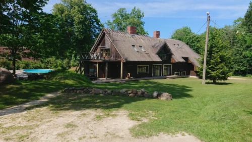an old house with a gambrel roof on a yard at Reimani Holiday House in Vanaveski