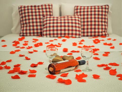 a bed with two wine glasses and flowers on it at Aqua & Terra Traditional Cave Houses in Oia