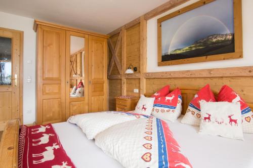 a bedroom with a bed with red and white pillows at Ferienhof Margarethengut in Unterach am Attersee