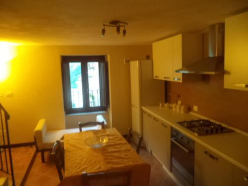 eine Küche mit einem Tisch und eine Küche mit gelben Wänden in der Unterkunft CASA DELL'ARCO in Calatafimi