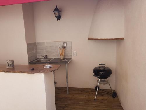 a kitchen with a sink and a chair in a room at Le Leon d'or in Mirepoix