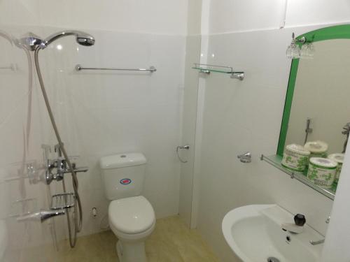 a white bathroom with a toilet and a sink at Ella Jayamali Holiday Pavilion in Ella