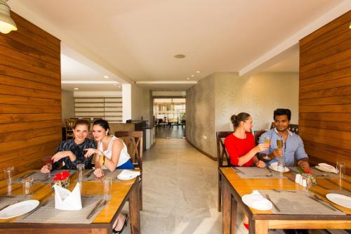 a group of people sitting at a table in a restaurant at The Fern Residency, Miramar in Panaji