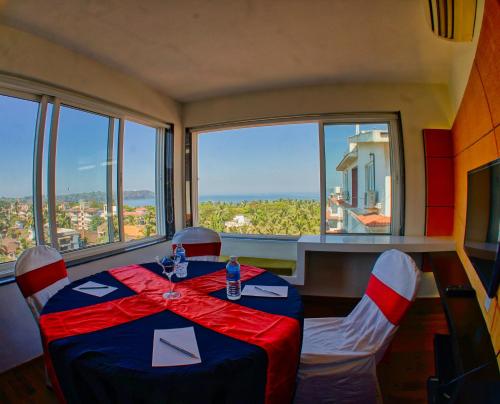 a dining room with a table and chairs and a large window at The Fern Residency, Miramar in Panaji