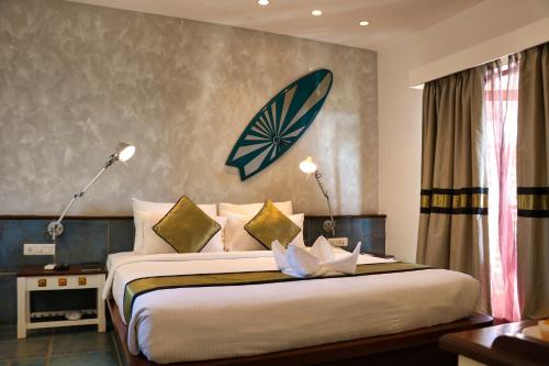 a bedroom with a large bed with two lights on it at The Fern Residency, Miramar in Panaji