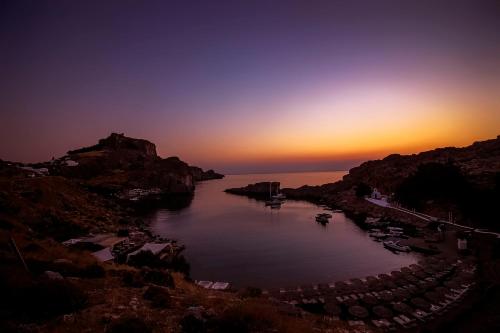a view of a river at sunset with boats in it at Lindos Citrin Studios in Líndos