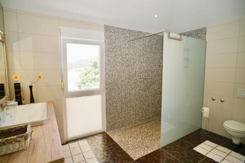 baño con ducha y aseo y ventana en Luxury Penthouse, en Seget Vranjica
