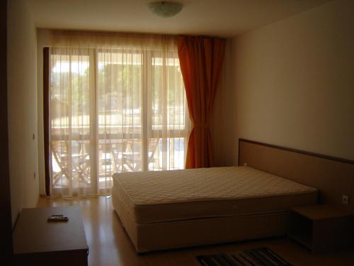 a bedroom with a bed and a large window at Byala Palace Apartments in Byala