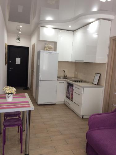 Il comprend une cuisine équipée d'un réfrigérateur blanc et d'une table. dans l'établissement Cozy apartment near the airport "Kyiv", à Kiev