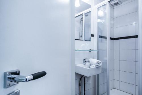 a white bathroom with a sink and a shower at Patrick's Place in Amsterdam