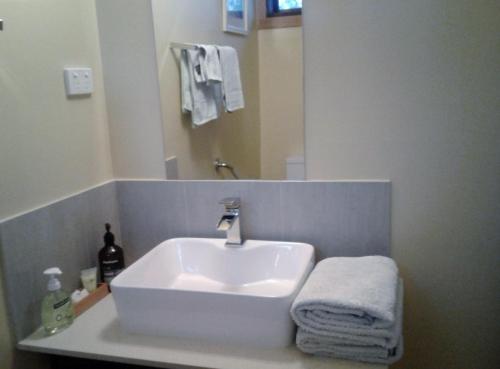 a white sink in a bathroom with a mirror at Woodenbong Bed and Breakfast in Woodenbong