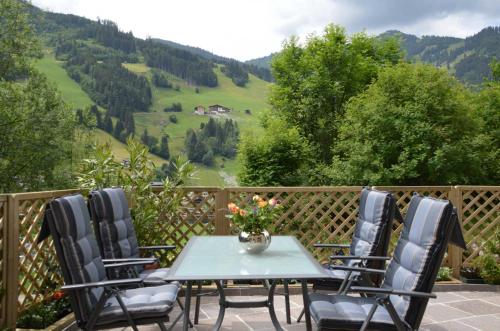 a table and chairs on a balcony with a view of a valley at Ferienwohnung am Sonnseitweg in Grossarl