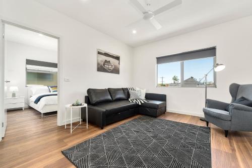 a living room with a couch and a bed at Rosewater Townhouses Dromana in Dromana