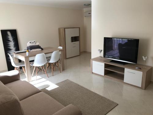 a living room with a couch and a tv and a table at Villa Lota in Vila Nova De Cacela
