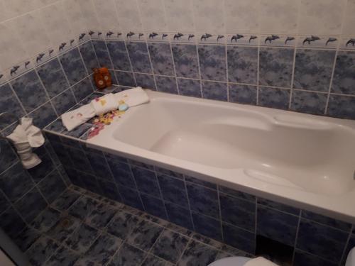 a bath tub in a bathroom with blue tiles at Blue House - Синята къща in Obzor