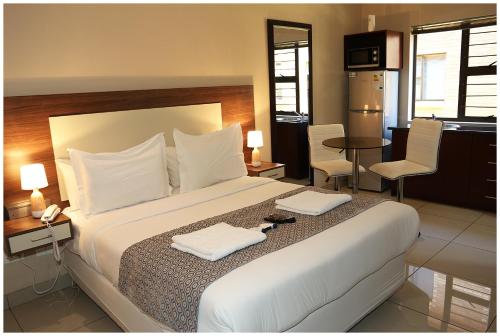 a bedroom with a large bed with two white towels at Eagle Nest Luxury Accommodation in Roodepoort