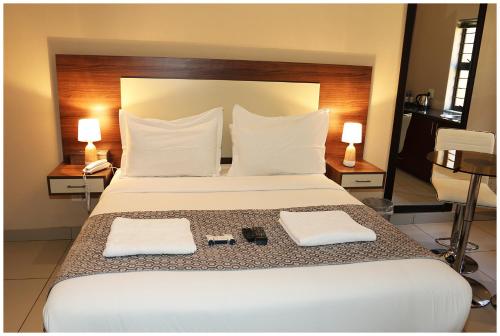 a bedroom with a large white bed with two towels at Eagle Nest Luxury Accommodation in Roodepoort