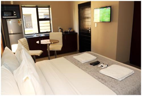 a bedroom with a bed with a television and a table at Eagle Nest Luxury Accommodation in Roodepoort