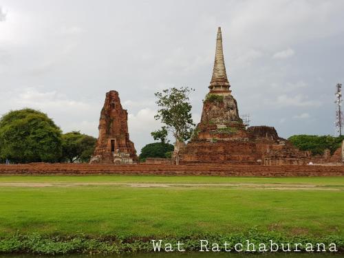 eine Gruppe von Tempeln auf einem Feld mit grünem Gras in der Unterkunft Baan Baimai Boutique Room in Phra Nakhon Si Ayutthaya