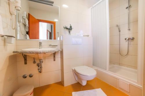 a bathroom with a toilet and a sink and a shower at Hotel Merlot in Opuzen