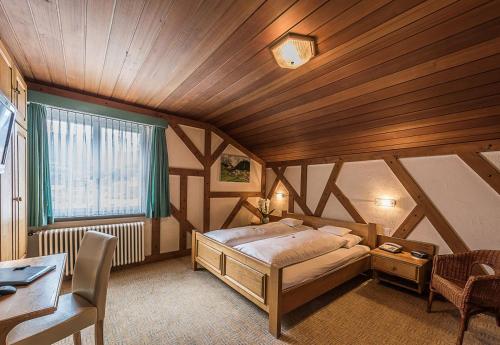 una camera con letto e soffitto in legno di Hotel Romana a Savognin