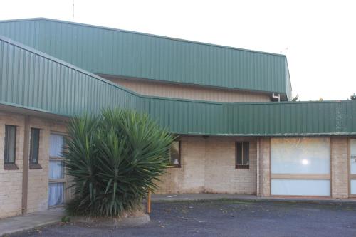 a large green building with a tree in front of it at Mt Gambier International in Mount Gambier