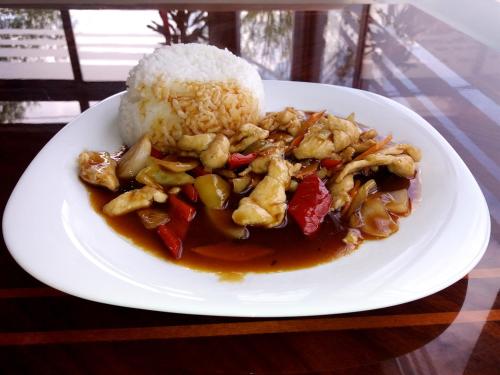 a plate of food with chicken and rice on a table at Hotel & Restaurant Great Wall - Airport in Sarajevo