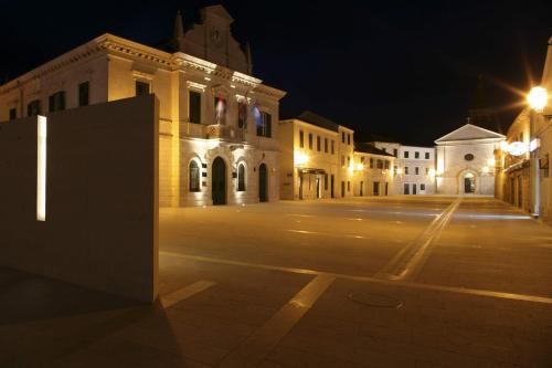 an empty street at night with a building at Hotel Merlot in Opuzen