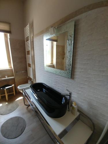 a bathroom with a black sink and a mirror at Diadumeno Superior Apartment in Venosa
