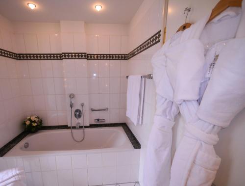 a white bath tub in a bathroom with towels at Villa Hammerschmiede in Söllingen