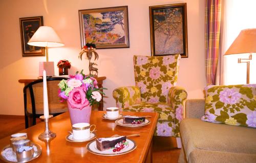 a living room with a table with cake and chairs at Villa Hammerschmiede in Söllingen