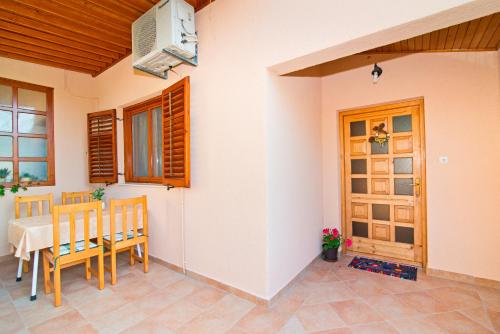 een eetkamer met een tafel en stoelen en een deur bij Apartment Šare in Betina