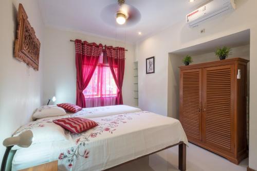 a bedroom with a large bed and a window at Dennis Holiday Bungalow in Jasri