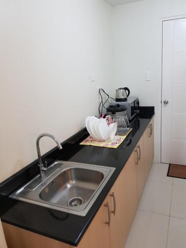 a kitchen counter with a sink and a microwave at Milagrosa(SMDC wind residences) in Tagaytay