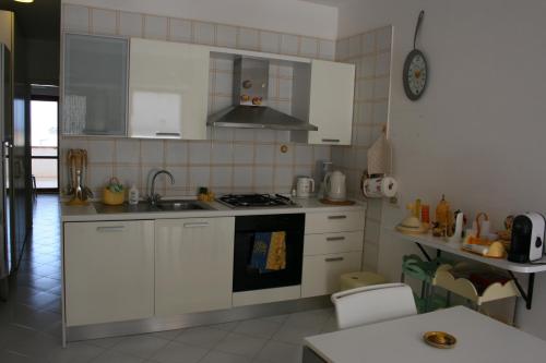 a kitchen with white cabinets and a stove top oven at Casa Del Mulino in San Vito lo Capo