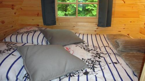 a bed with six pillows on it with a window at Tonn"O Loisirs in Servel