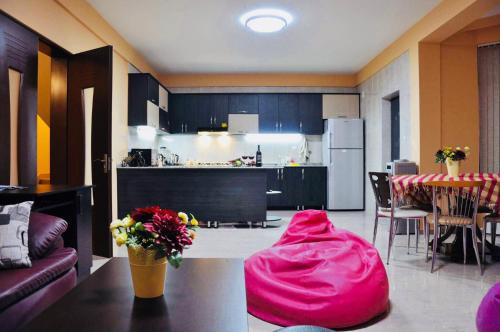 eine Küche mit einem Tisch und einer rosa Decke darauf in der Unterkunft Villa Georgiana in Gonio