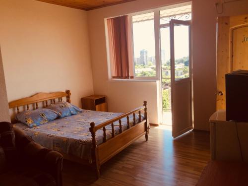 a bedroom with a bed and a large window at Mandarinoviy Sad in Gagra