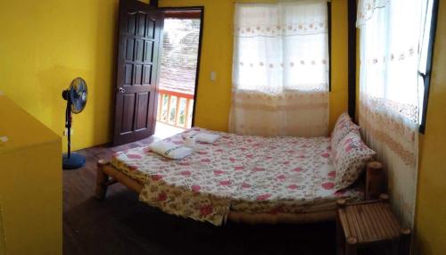 a bedroom with a bed in a room with a window at Guanna's Place Room and Resto Bar in Malapascua Island
