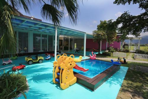 a house with a pool with a play equipment in it at An Ti Li Ya Homestay in Dongshan