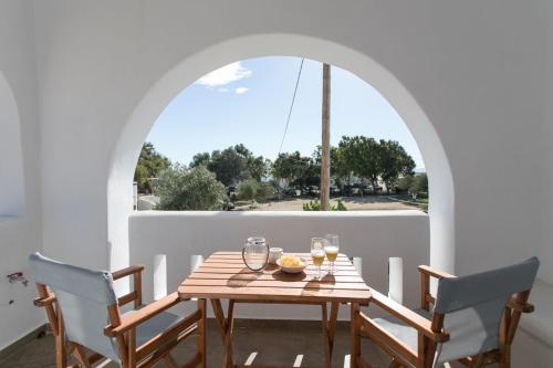 a table with glasses and a bowl of food on a balcony at Keti Kapri in Plaka